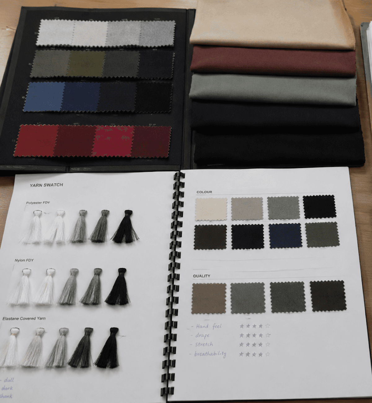Fabric swatch books and a yarn swatch page showing polyester, nylon and elastane samples with colour and quality ratings